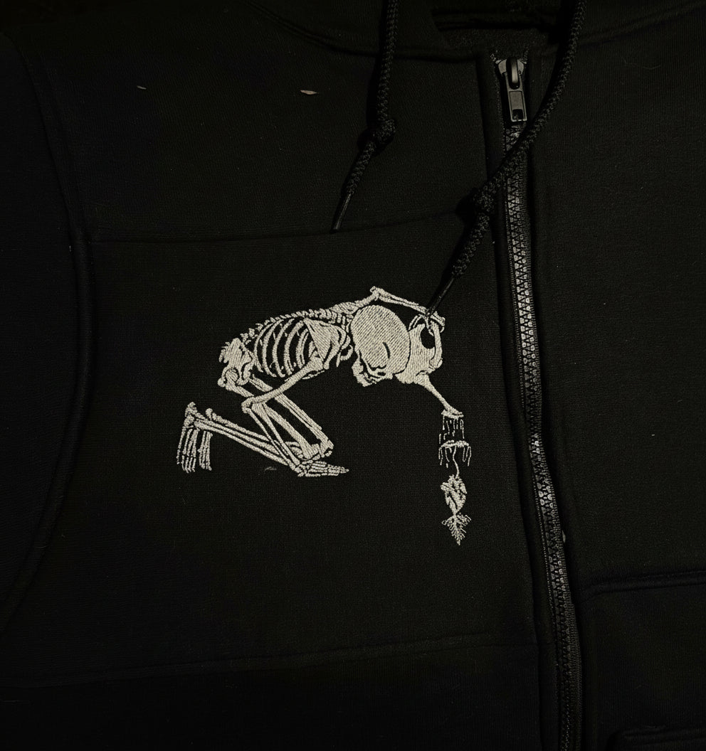 Black hoodie with a white skeleton design on the chest.